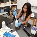 A student mixing chemicals in a laboratory.