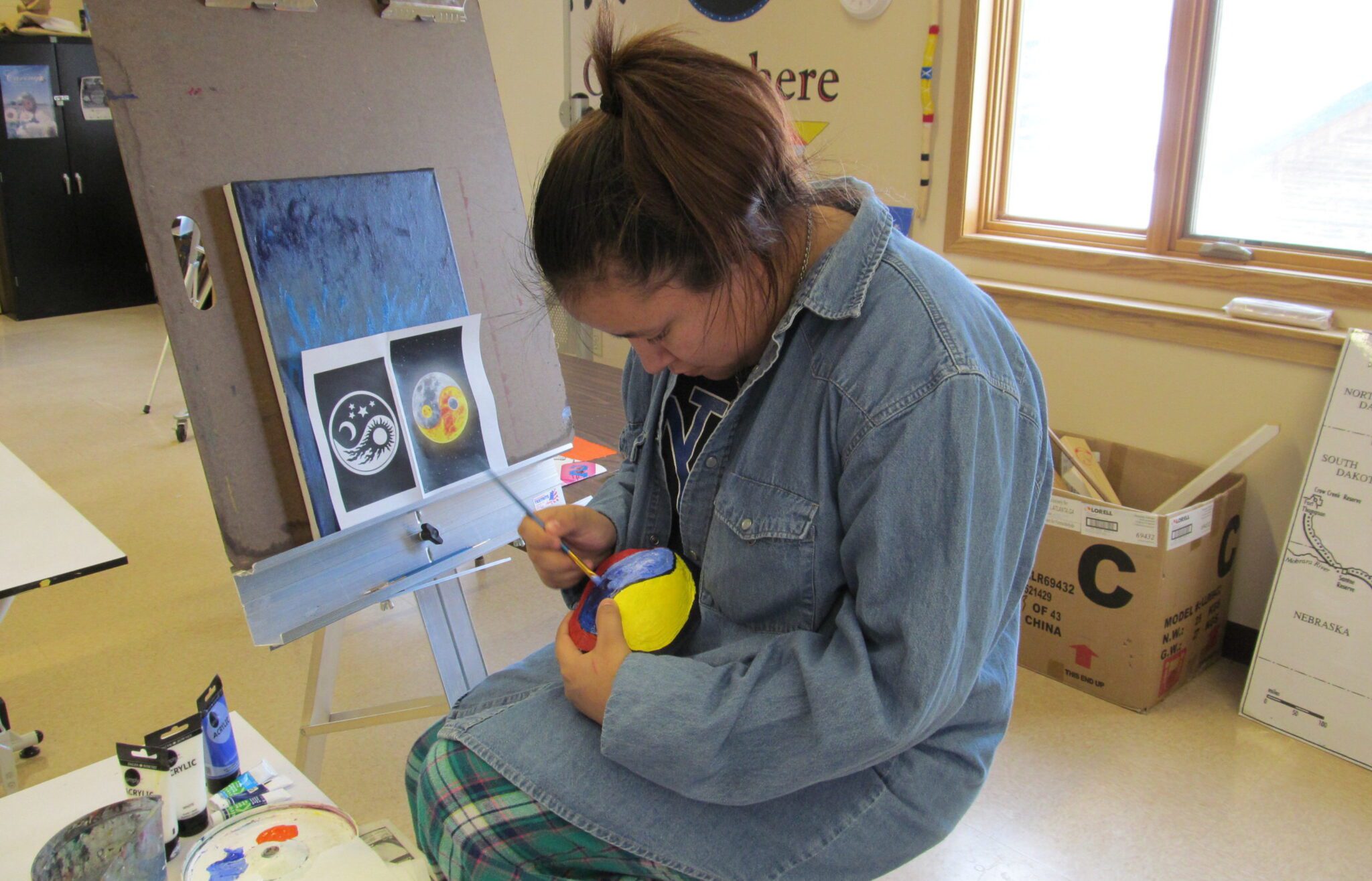 A woman painting an unknown object.