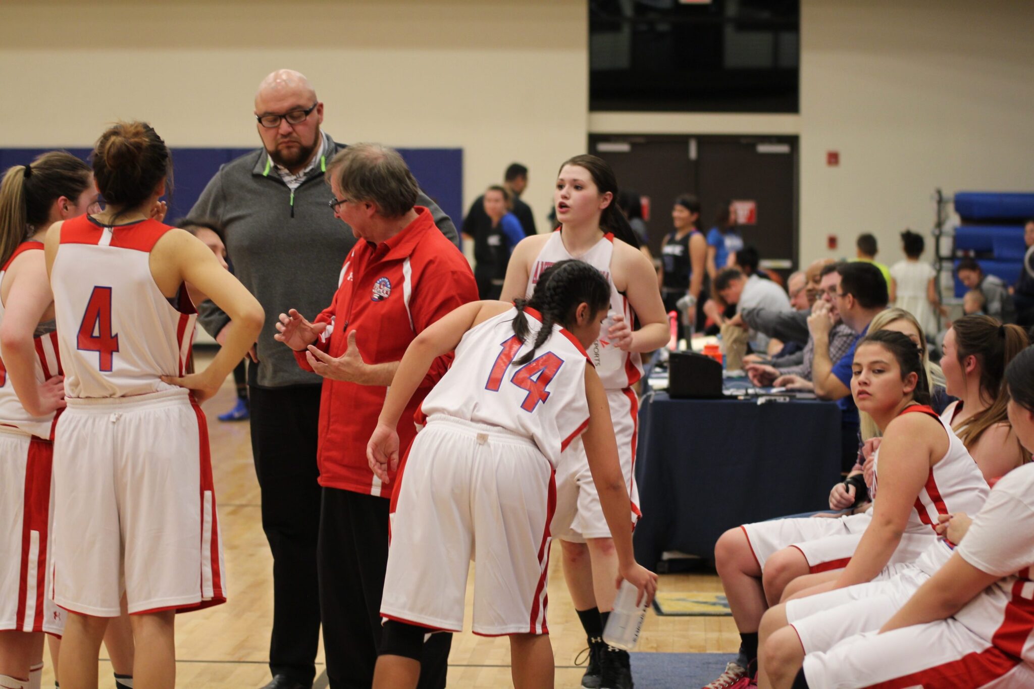 The women's basketball team huddling during a timeout.