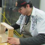 A man building a wooden box in a shop.