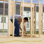 A man framing a building with wood.