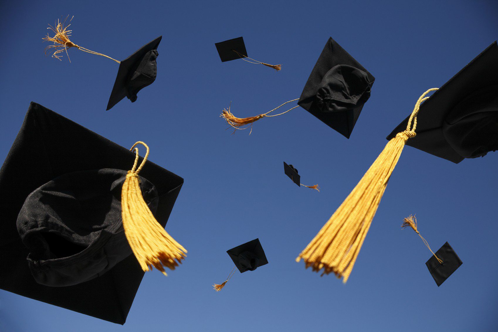 Graduation caps flying in the air.