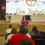 A women presenting to an audience.