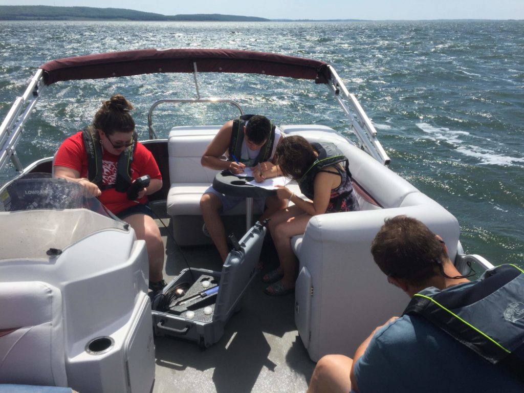 Students on a boat collecting readings for their Natural Resource Management class.
