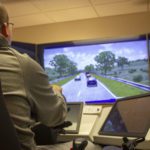 A man testing his truck driving skills on a simulator.