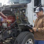 A man inspecting a semi-truck.