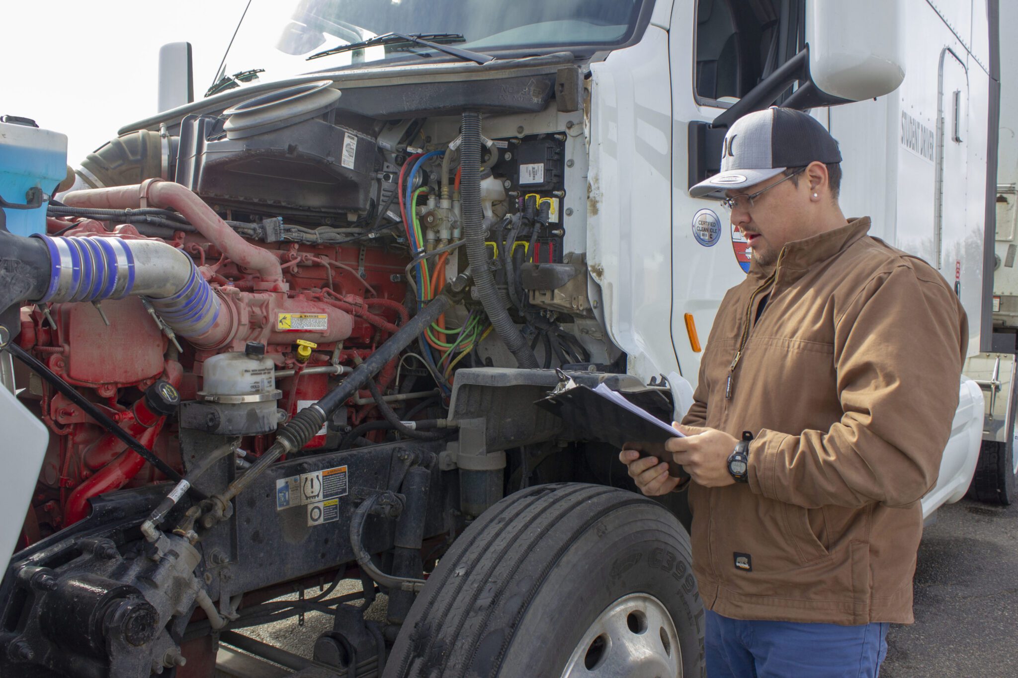 A man inspecting a semi-truck.